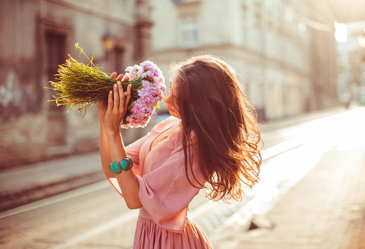 Soft girl w romantycznej pastelowej sukience z kwiatami w rękach.